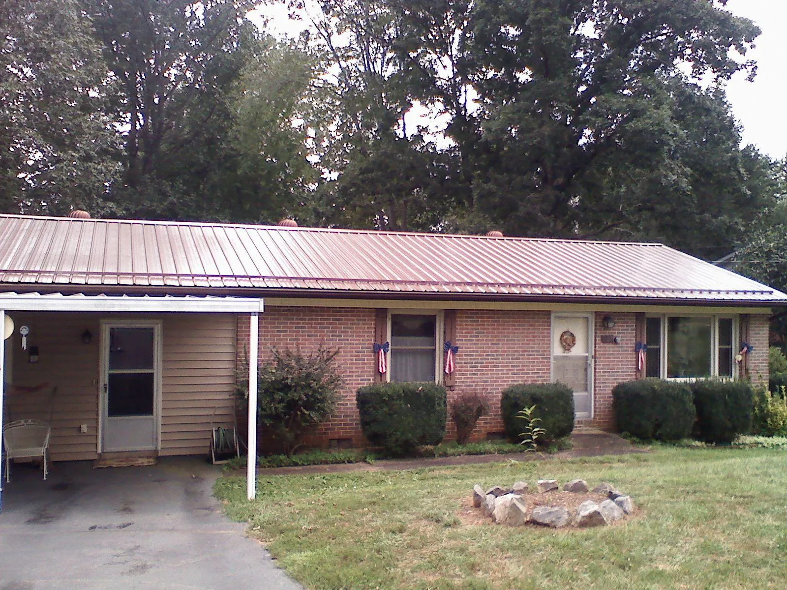 Bronze metal roof and carport on a brick ranch home — Roof Repair work by our crew in West River